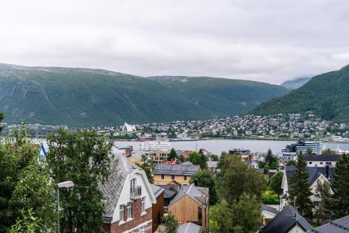 a town with a river and mountains in the background at View of Tromsø in Tromsø