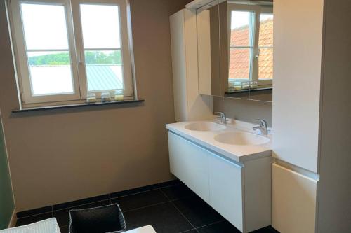 uma casa de banho com 2 lavatórios e um espelho em Duplex Appartement Nokeredorp - Vlaamse Ardennen em Kruisem