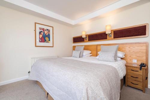 a bedroom with a large bed with a wooden headboard at Bayview Hotel in Bushmills
