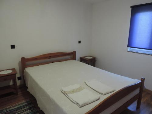 a bedroom with a bed with two towels on it at Casa das Pedras in Vieira do Minho
