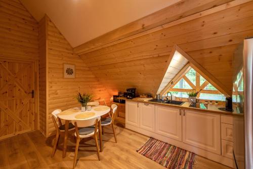 a kitchen with a table and chairs in a cabin at Osada Sudecka in Lądek-Zdrój