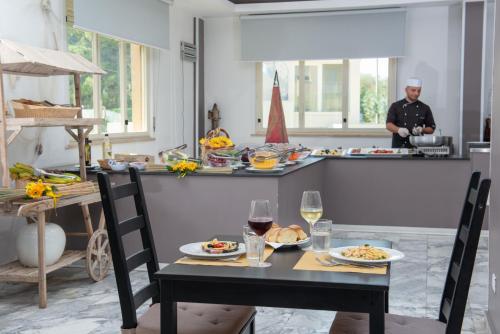 a table with food and a man in a kitchen at Hotel President Sea Palace in Noto Marina