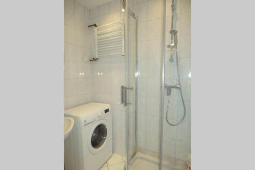 a bathroom with a washing machine and a shower at Apartment Ogarna 35/36 on the Gdańsk Old Town in Gdańsk