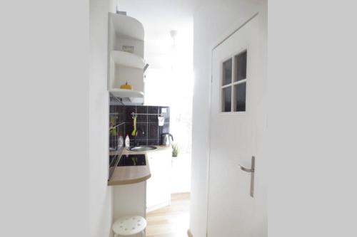 a kitchen with white walls and a white door at Apartment Ogarna 35/36 on the Gdańsk Old Town in Gdańsk