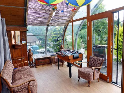 Zimmer mit einem Tisch und Stühlen in einem Zimmer mit Fenstern in der Unterkunft "Balmgarten" im Naturpark Usedom, Bio Solarhaus mit großem Garten in Balm