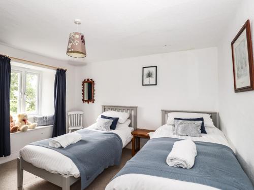 two beds in a room with a window at Hilber Cottage in Ambleside