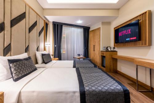 Endican Sultanahmet Hotel في إسطنبول: غرفة فندقية بسريرين وتلفزيون بشاشة مسطحة