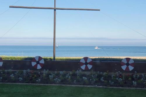 a fence with red and white arrows on it near the ocean at Appartement, Les TEMPLIERS, RDC VUE MER PROCHE CENTRE VILLE in Houlgate
