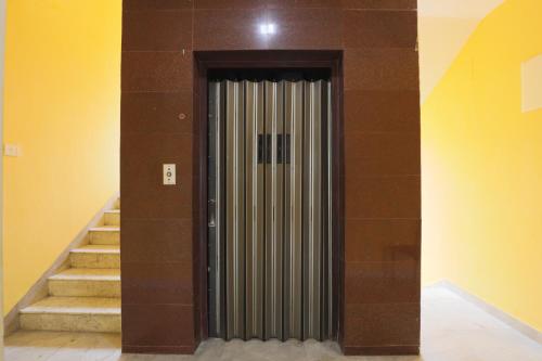 a metal door in a room with stairs at Green Tree Hotel-Near VFS Global and Ramee Mall in Chennai