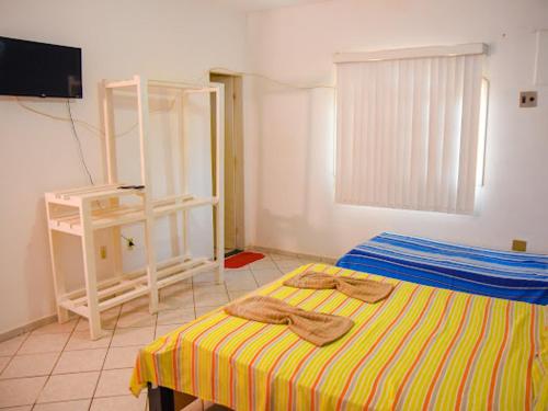 a bedroom with a bed with two towels on it at Pousada Ikaro in Guarapari