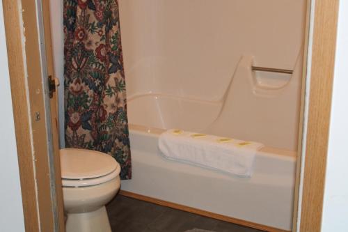 a bathroom with a toilet and a bath tub at adoba® Dreamland in Gulliver