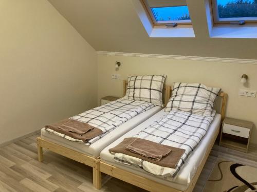 2 camas individuales en una habitación con techo en Tisza-Holtág Apartman Tiszadada, en Tiszadada