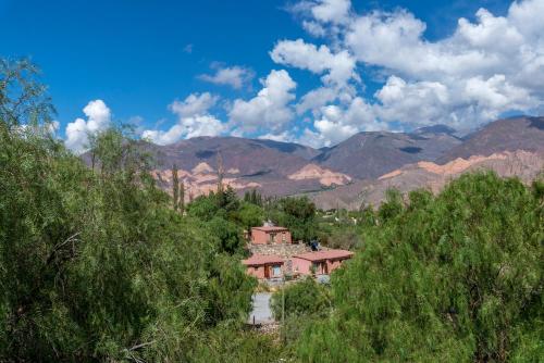 a house in the middle of a valley with mountains at Villa del Cielo in Tilcara