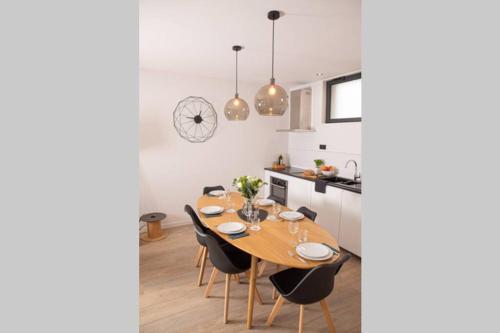 une cuisine et une salle à manger avec une table et des chaises en bois dans l'établissement Le Clos du fond Cailloux - Gîte 2 à 7 personnes, à Longuenesse