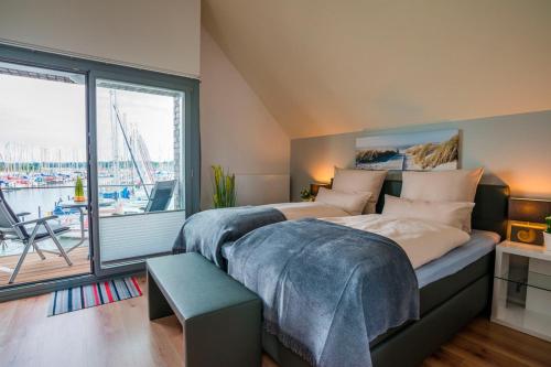 two beds in a room with a large window at Ostsee - Maisonette - Appartement Nr 53 "Schöne Aussicht" im Strand Resort in Heiligenhafen