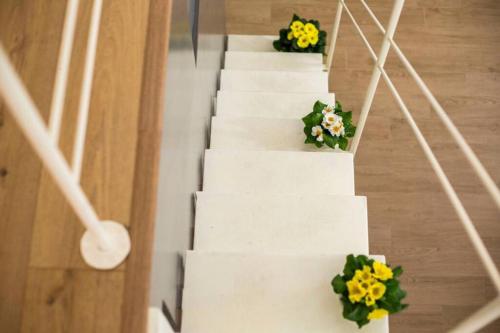 拉泰爾札的住宿－Perry Loft，白色的楼梯,花朵黄色和绿色