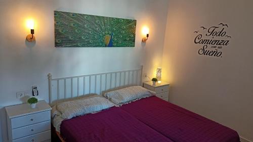 1 dormitorio con 1 cama con colcha púrpura en Acogedor adosado en Maspalomas-Sonneland, en Maspalomas