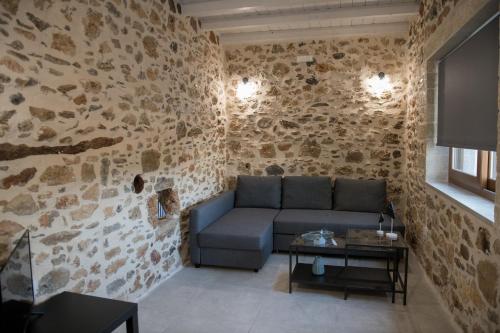 a living room with a couch in a stone wall at Petrino in Sisi with private pool and garden in Sissi