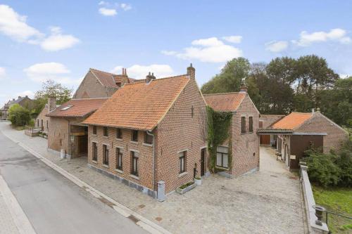 una vieja casa de ladrillo al lado de una calle en Domein Warandehof, en Gooik