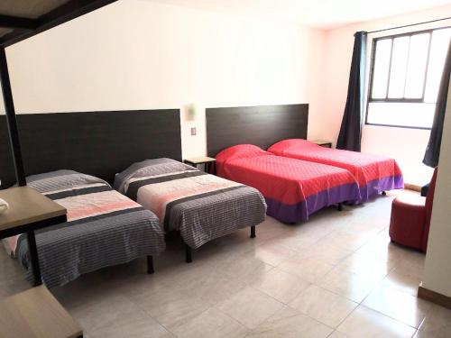 1 Schlafzimmer mit 2 Betten, einem Tisch und Stühlen in der Unterkunft Casa Republik in León