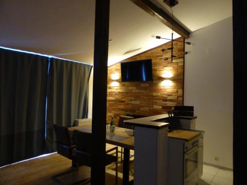 a room with a table and a television on a brick wall at Apartment Skyline of Jena, luxuriös, einzigartig, free Wifi, Parkplatz, klimatisiert, zentral in Jena