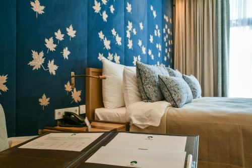 a room with a bed and a table with a couch at Dreamland Golf Hotel Baku in Baku