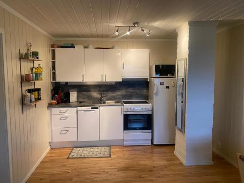 cocina con armarios blancos y nevera en Panorama Vardø, en Vardø