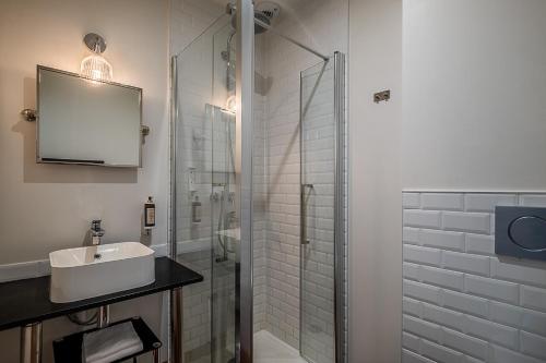 a bathroom with a sink and a glass shower at IKO Bordeaux Appartements in Bordeaux