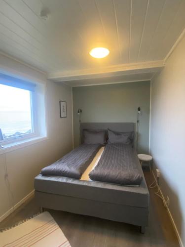 a bed in a small room with a window at Panorama Vardø in Vardø