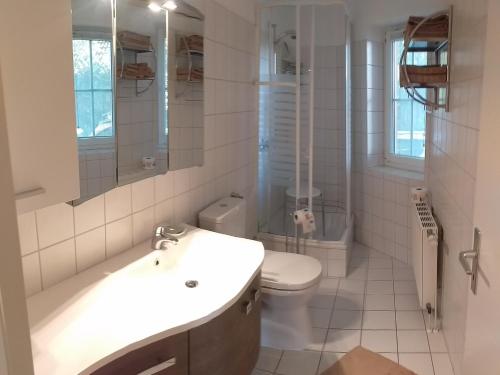 Baño blanco con lavabo y aseo en Laboe-Appartement im Kapitänshaus, en Laboe