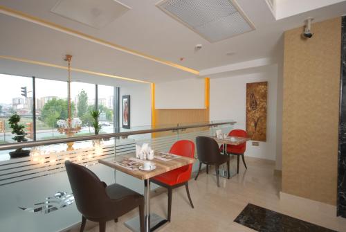 a dining room with red chairs and a table at Imamoglu Pasa Butik Hotel in Kayseri