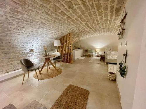 a living room with a stone ceiling and a table and chairs at La Maison Pinot Noir in Gevrey-Chambertin