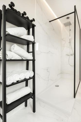 a bathroom with a black towel rack with towels at Villa My Corner in De Panne