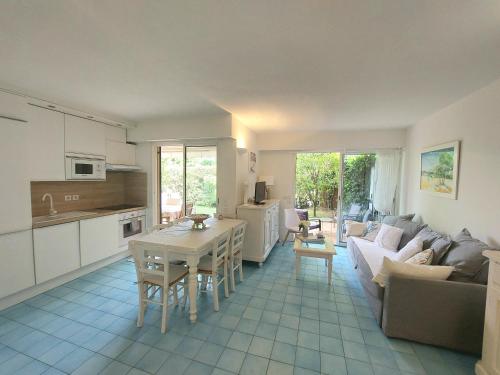 een keuken en een woonkamer met een bank en een tafel bij Plage la Salis 3 chambres, Jardin - 3 bedrooms in Antibes