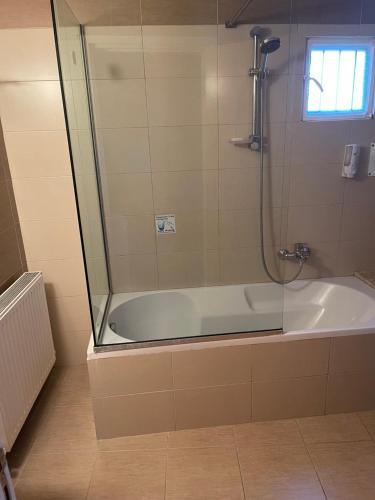 a bathroom with a shower and a bath tub at Omodos Village Houses in Omodos
