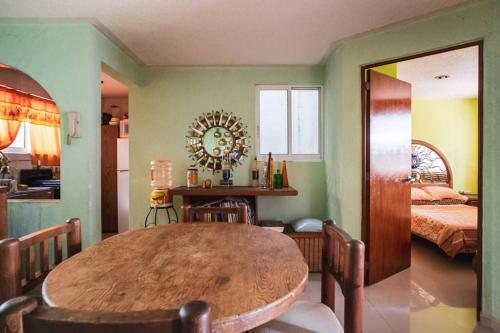 a dining room with a wooden table and a bedroom at Rincón de Checo in Mexico City