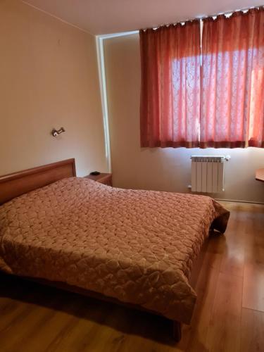1 dormitorio con cama y ventana roja en Edelweiss Inn Apartment 20, en Bansko