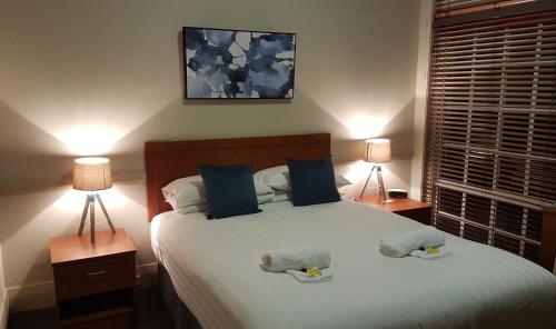 米塔贡Highlands Hotel的卧室里有一张白色的大床，床边还有两盏灯