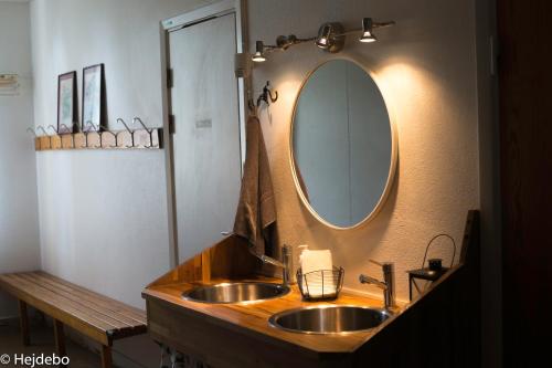 a bathroom with a sink and a mirror on the wall at Hejdebo Vandrarhem in Hejde