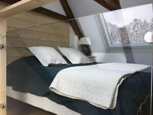 une chambre avec un lit avec une tête de lit en bois et une fenêtre dans l'établissement LE DOMAINE DE LA LOUVE BLANCHE, à Le Mont-Dore