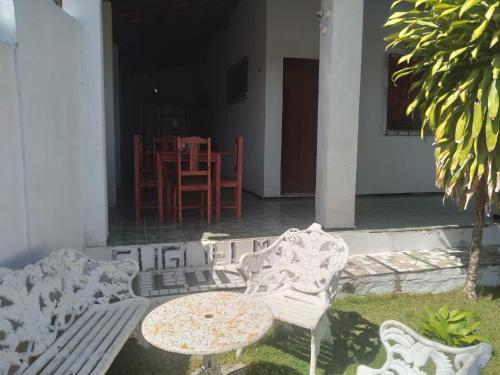a patio with two white benches and a table at Paracuru HolaOnda WaveHostel in Paracuru