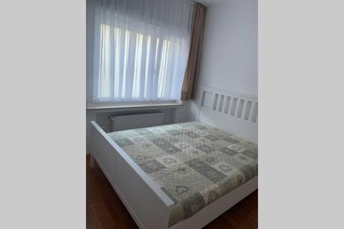 ein kleines Bett in einem Zimmer mit Fenster in der Unterkunft Ferienwohnung in Wiesbaden in Wiesbaden