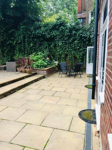 a patio with chairs and a table next to a building at Vincent House London Residence in London