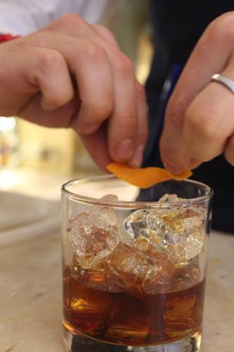 a person is stirring a drink in a glass at Mansion Alcazar in Cuenca