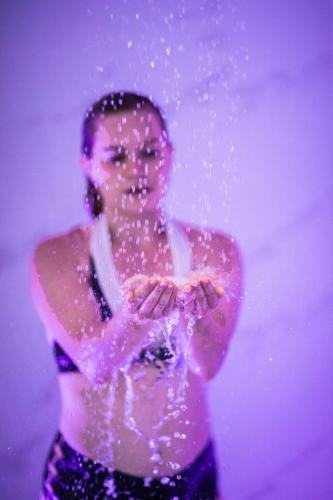 a woman standing in the water with water pouring off her hands at La Maison TATIN in Lamotte-Beuvron