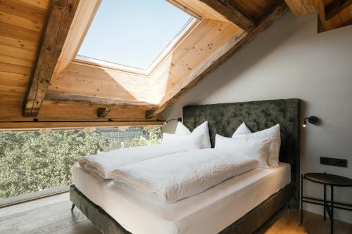 a bedroom with a bed with a large window at St. Vigilius modern historic apartments in Nalles