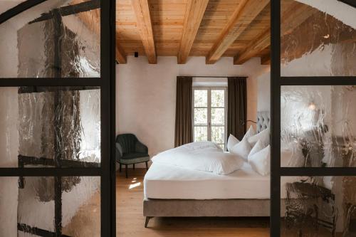 a bedroom with a bed and a window at St. Vigilius modern historic apartments in Nalles
