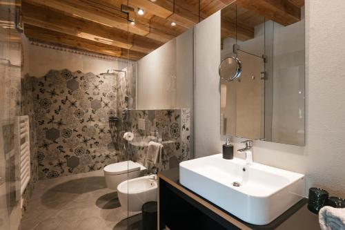 a bathroom with a sink and a toilet at St. Vigilius modern historic apartments in Nalles