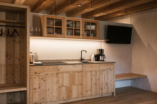 a kitchen with wooden cabinets and a sink at St. Vigilius modern historic apartments in Nalles