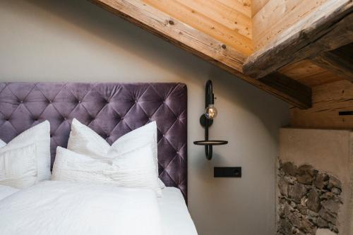 a bedroom with a bed with a purple headboard at St. Vigilius modern historic apartments in Nalles